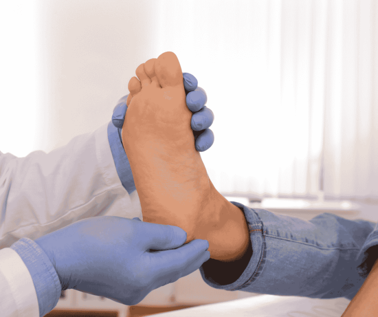 Podiatrist with blue gloves on assessing patients foot for heel pain
