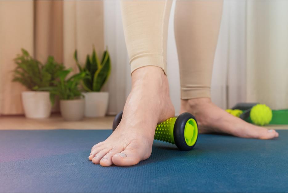 person rolling arch on roller right foot to relieve arch pain